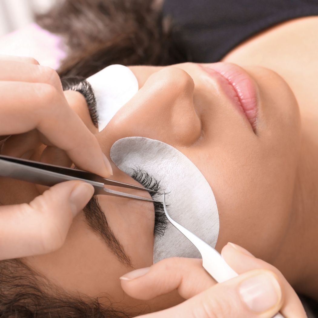 Wimpernverlängerung bei Glamskin: einzelne Wimpern werden mit einer Pinzette angebracht.